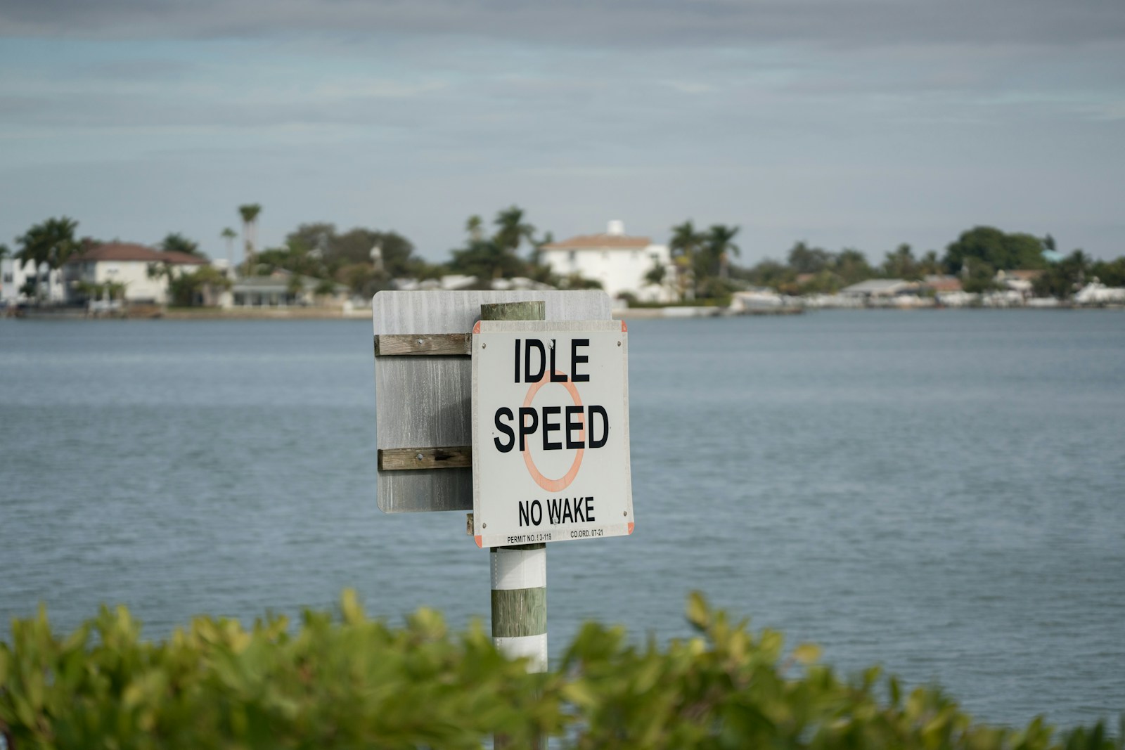 white wooden signage near body of water during daytime